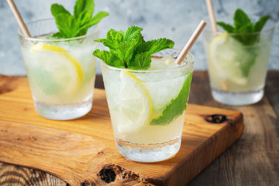 Two glass with lemonade or mojito cocktail with lemon and mint, cold refreshing drink.