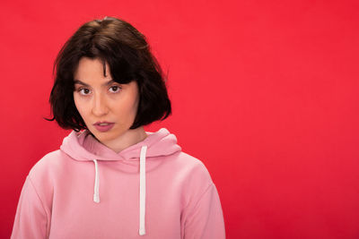 Portrait of a teenage girl against red background