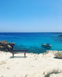 Scenic view of beach against clear blue sky