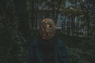 Man wearing mask against trees