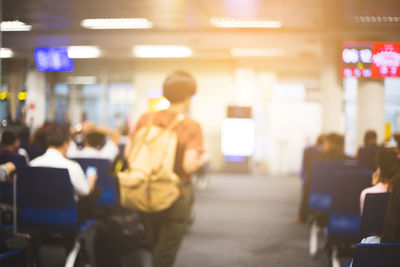 Rear view of people walking in illuminated train