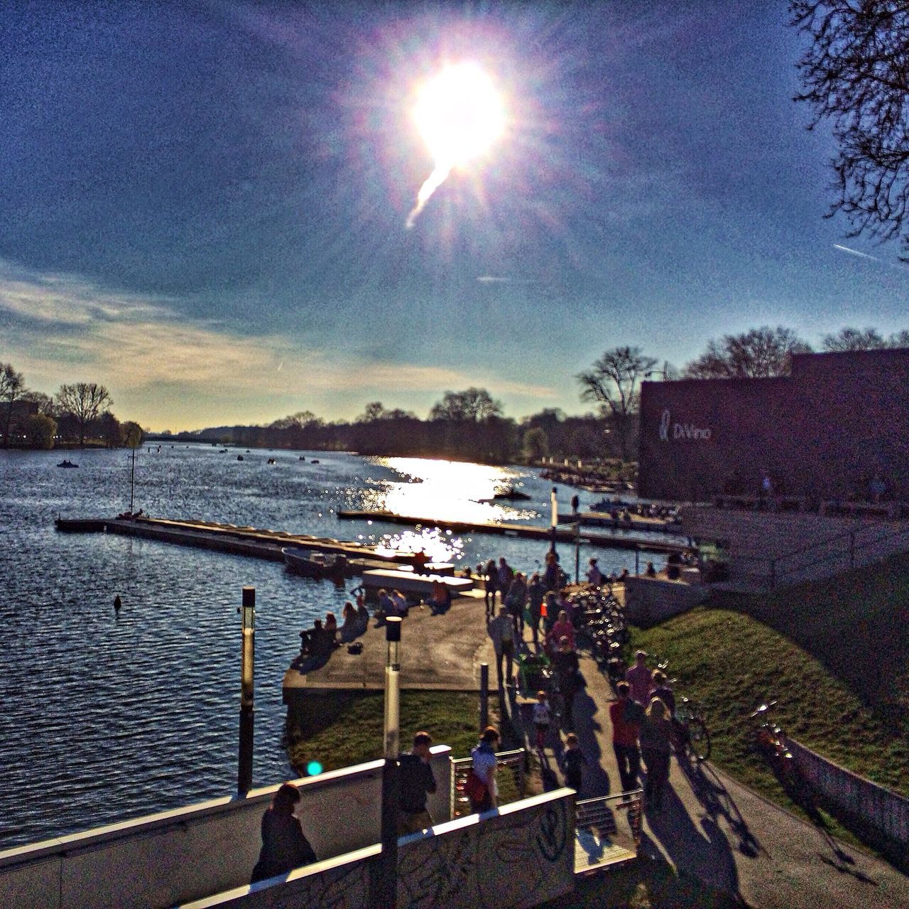 sun, sunlight, sunbeam, sky, water, lens flare, built structure, sunny, building exterior, architecture, railing, river, tree, nature, day, blue, cloud - sky, tranquility, outdoors, bright