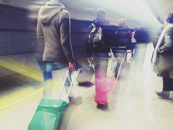 Blurred motion of woman standing on escalator