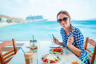 Portrait of woman sitting at beach