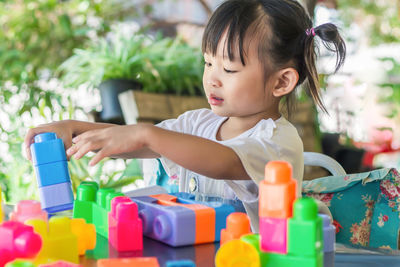 Cute girl playing with toy on table