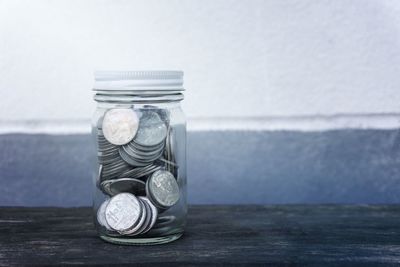 Close-up of coins in jar on table