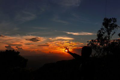 Silhouette man against orange sky during sunset