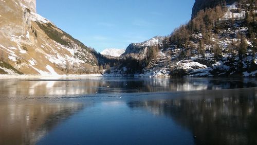 Scenic view of lake and mountains against blue sky