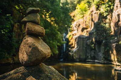 Rock balancing example in front of waterfall immersed in pristine nature. concept of meditation