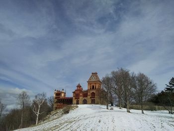 Building on field against sky during winter