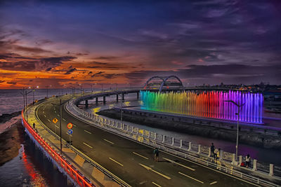 Light trails on road against sky at sunset