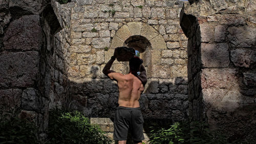 Rear view of man standing against wall