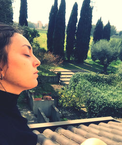 Portrait of woman looking at trees