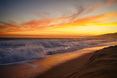 Scenic view of sea against cloudy sky during sunset