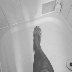 Low section of woman relaxing on tiled floor