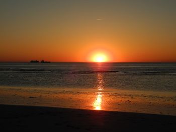 Scenic view of sea against orange sky