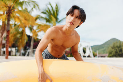 Low section of shirtless man exercising at beach