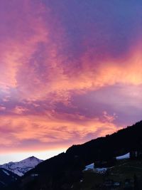 Scenic view of snowcapped mountains against sky at sunset