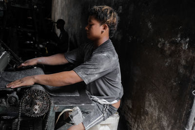 Man putting textile in machine at factory