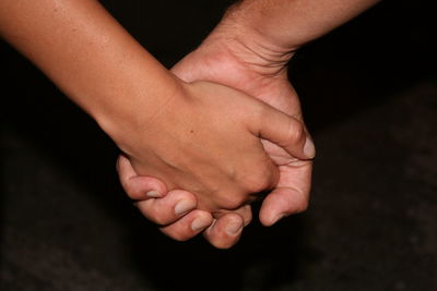 Close-up of hands against black background