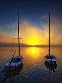 Sailboat sailing on sea against sky during sunset