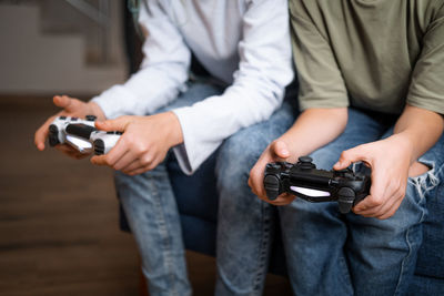 Midsection of man holding remote control