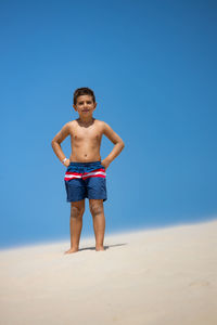 Portrait of a cute boy on a dune of a beach