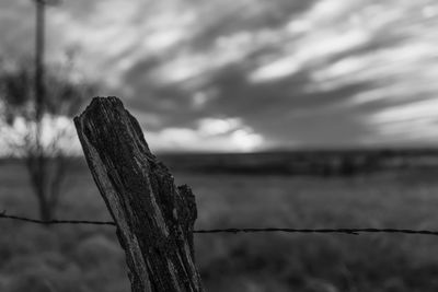 Close-up of wooden post against sky