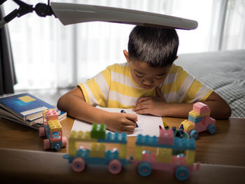 High angle view of boy coloring at table