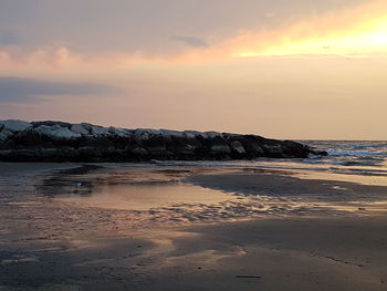 Scenic view of beach against sky during sunset