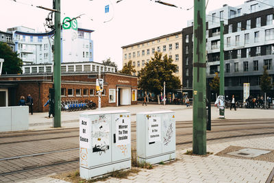 Text on wall in city against sky