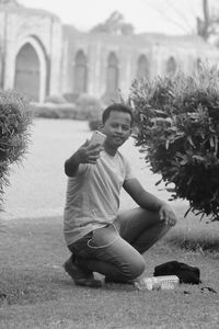 Portrait of young man sitting on field