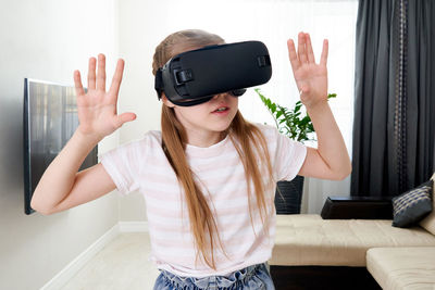 Girl wearing virtual reality simulator at home