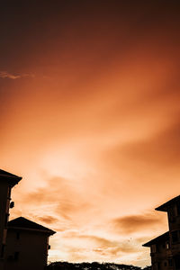 Low angle view of silhouette buildings against sky during sunset