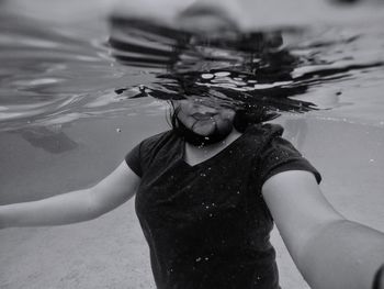 Midsection of woman swimming in pool