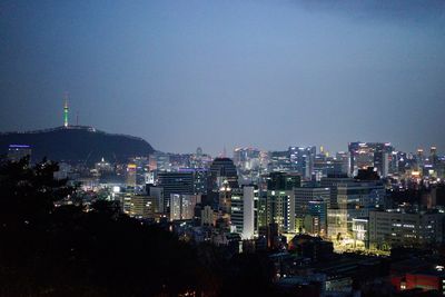 Illuminated buildings in city against sky at night