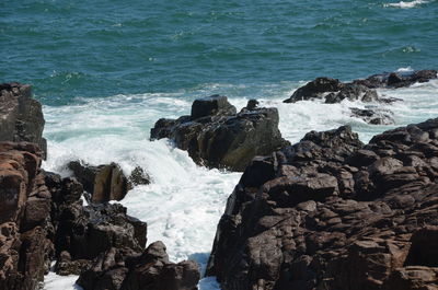 Panoramic view of sea waves splashing on rocks