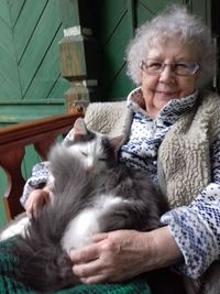 Portrait of senior woman sitting with cat at home