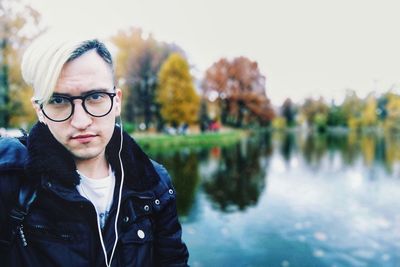 Portrait of man wearing eyeglasses against lake