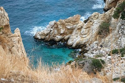 High angle view of rock formation by sea against sky