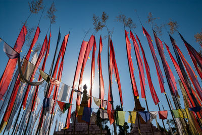 Low angle view of men standing against clear sky