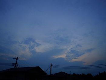 Low angle view of silhouette house against sky at sunset