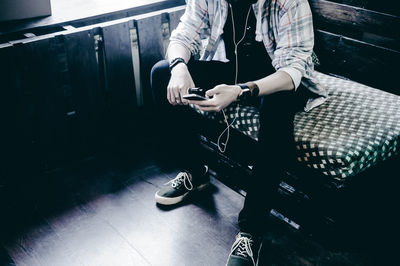Low section of man using mobile phone