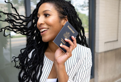 Portrait of a smiling young woman holding camera