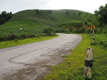 Road amidst field against sky