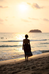 Rear view of full length of man standing on beach