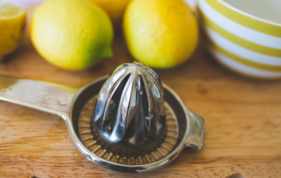 Fresh lemons with juicer on table