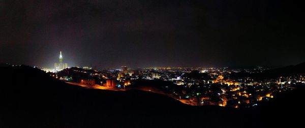 Illuminated cityscape against sky at night