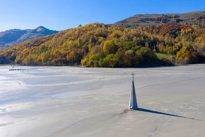 Aerial view of church flooded by mining residuals. apocalyptic scene, church tower in mud