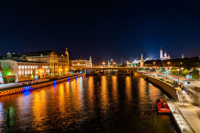 Illuminated bridge over river at night